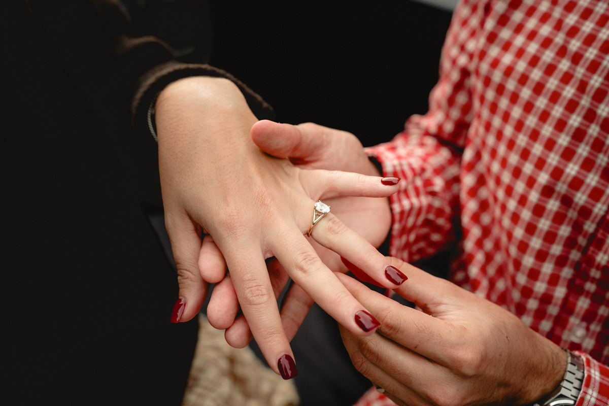 Close-up of an engagement ring placed on her hand.