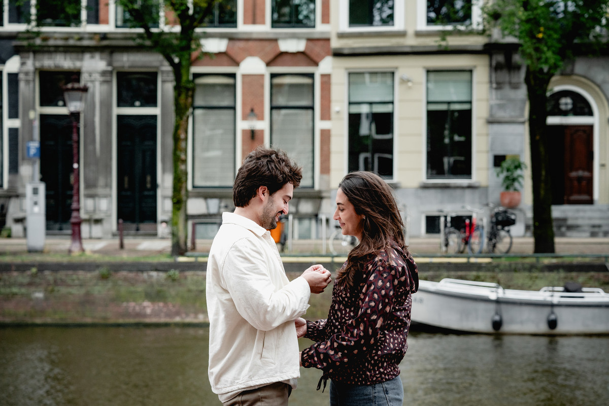 Couple walking hand in hand along an Amsterdam canal.
