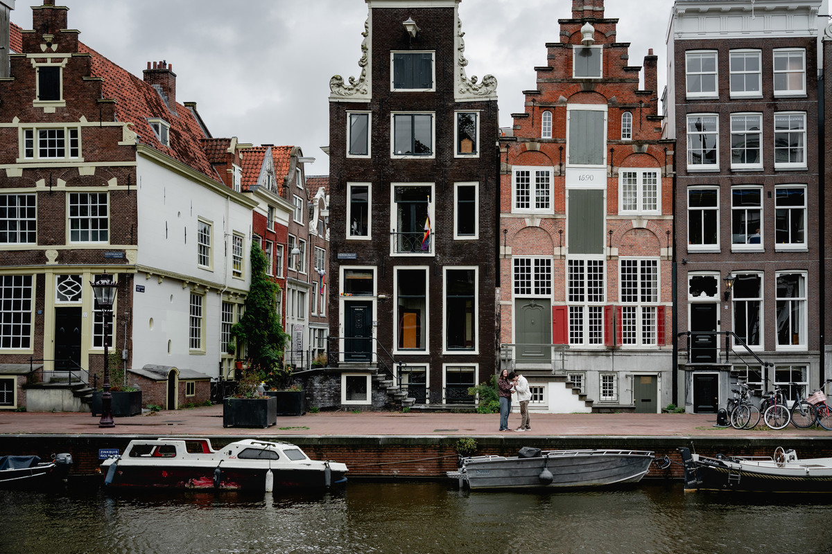 Historic Amsterdam canal houses reflected beside the water.
