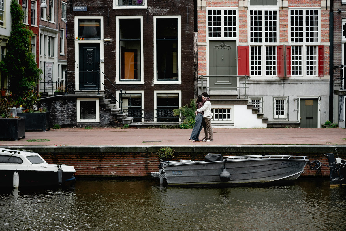 Wide view of Amsterdam canal houses during an engagement proposal.