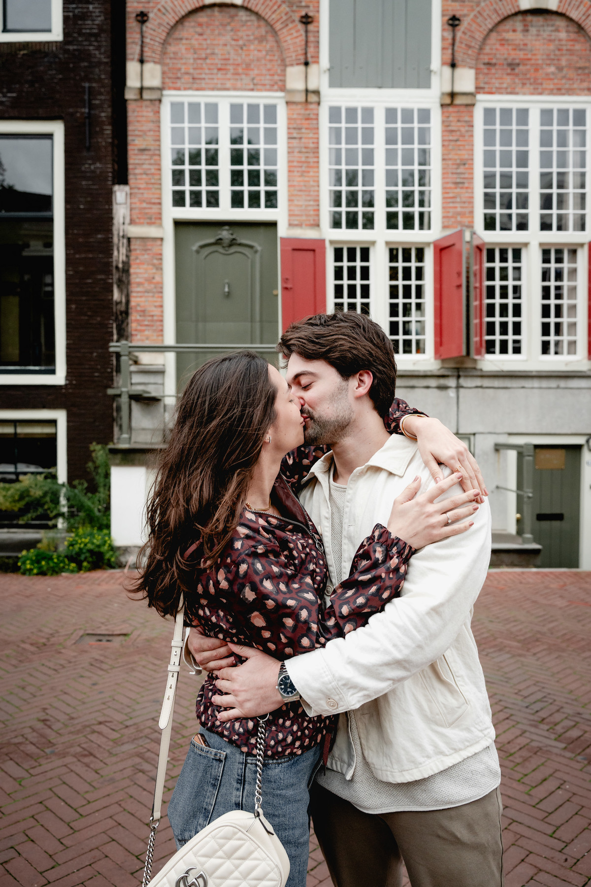 Couple kissing after their surprise proposal in Amsterdam.