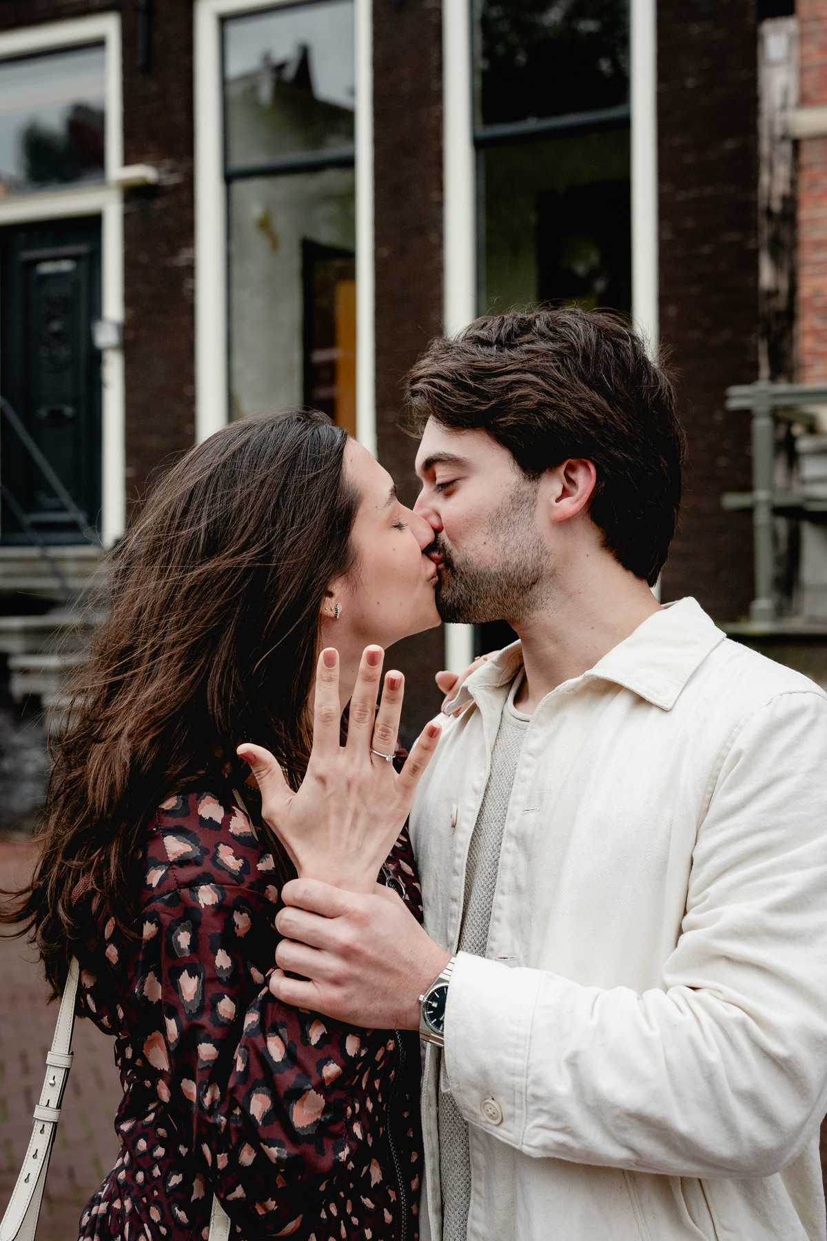 Close portrait of a newly engaged couple kissing beside the canal.