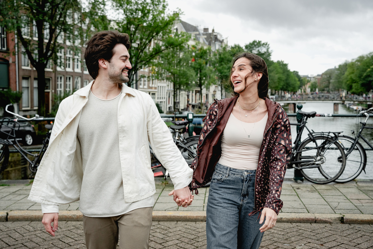 Couple holding hands during their engagement walk in Amsterdam.
