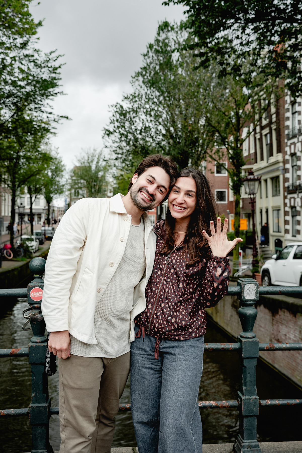  Newly engaged couple standing together on a quiet Amsterdam street.