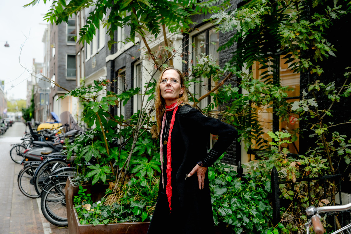 Woman posing beside bicycles and canal houses in Amsterdam.