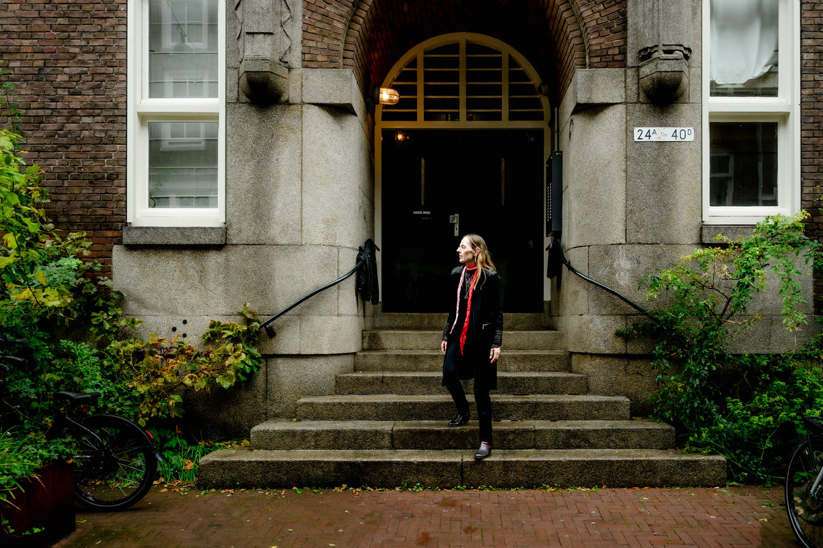 Woman standing at the entrance of a historic Amsterdam building.