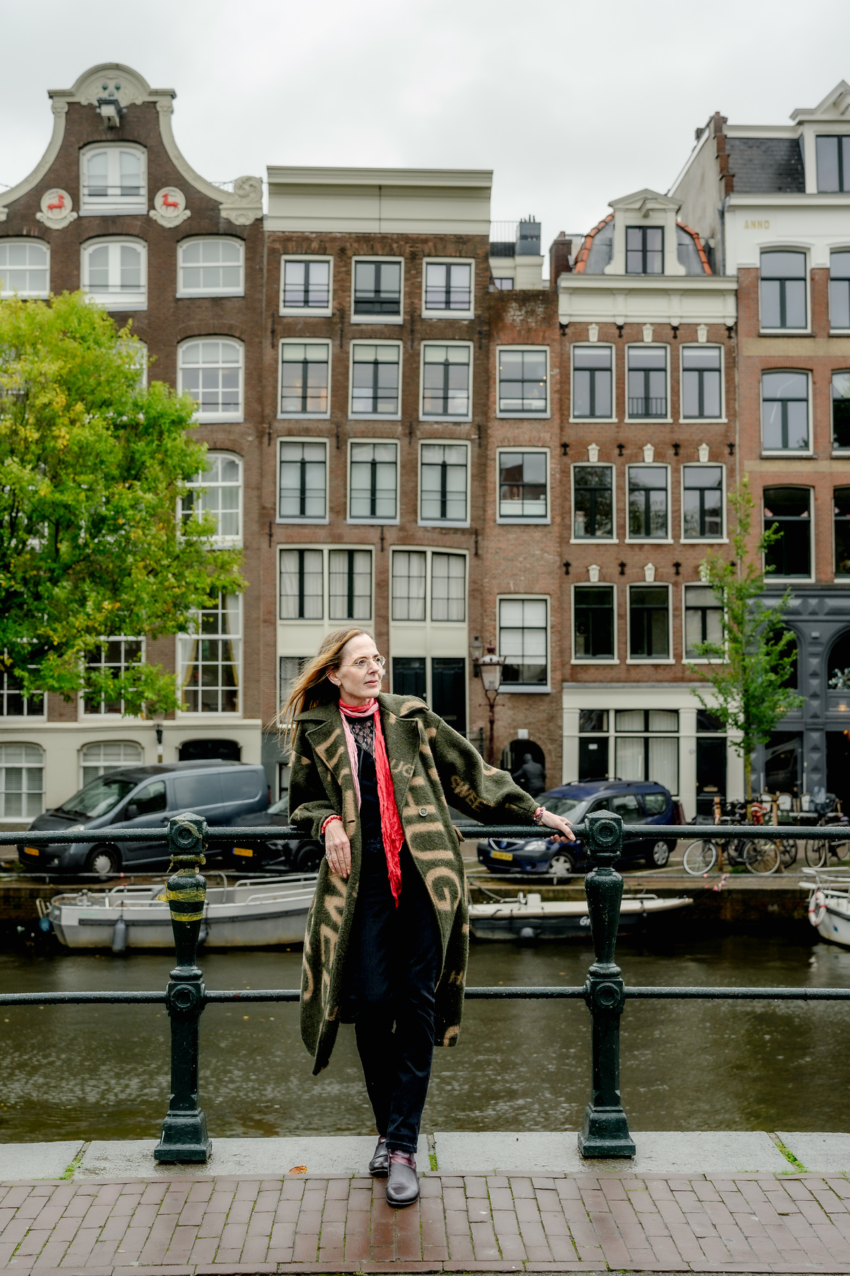 Solo portrait of a woman beside an Amsterdam canal bridge.