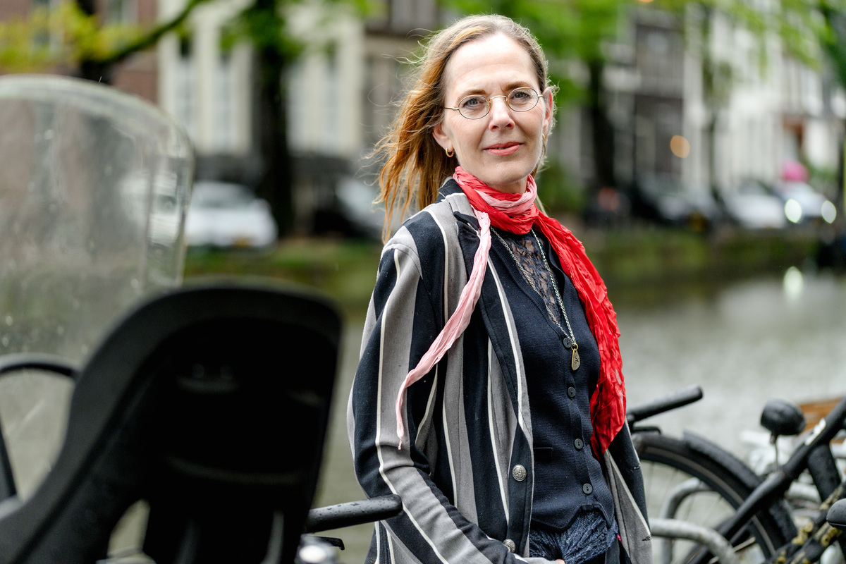 Editorial portrait of a woman beside an Amsterdam canal.