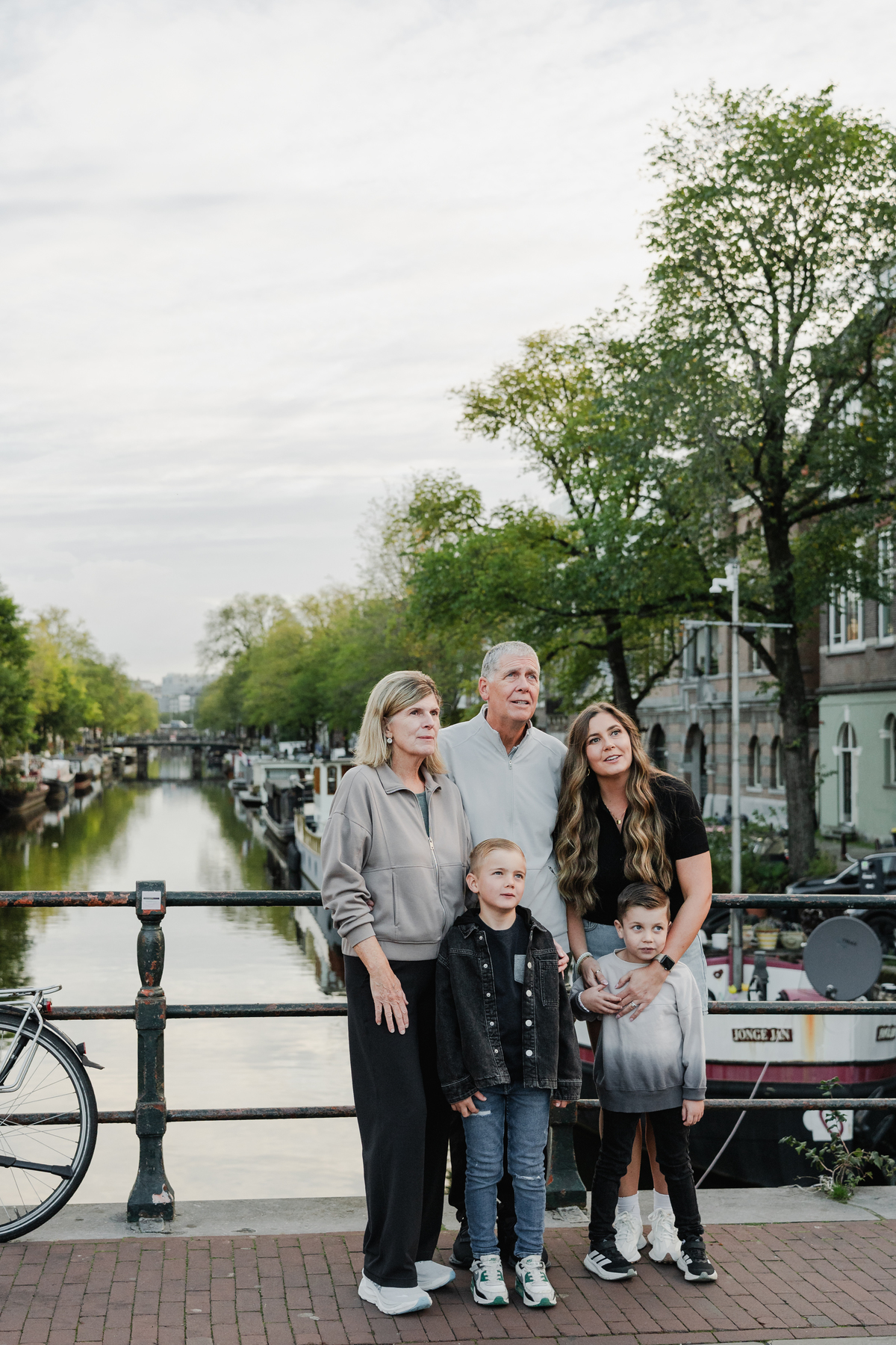 Family of grandparents, parents and children standing beside an Amsterdam canal.