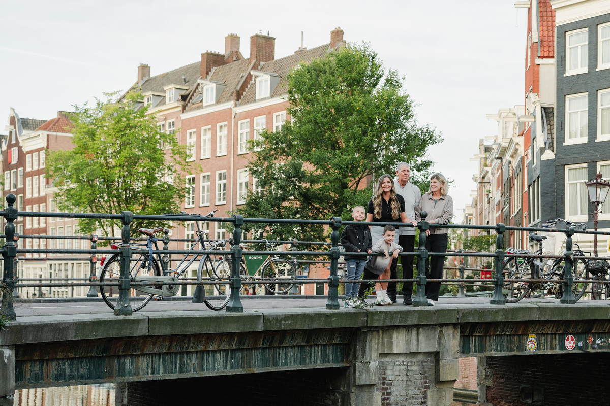 Wide family portrait beside an Amsterdam canal in the Jordaan.