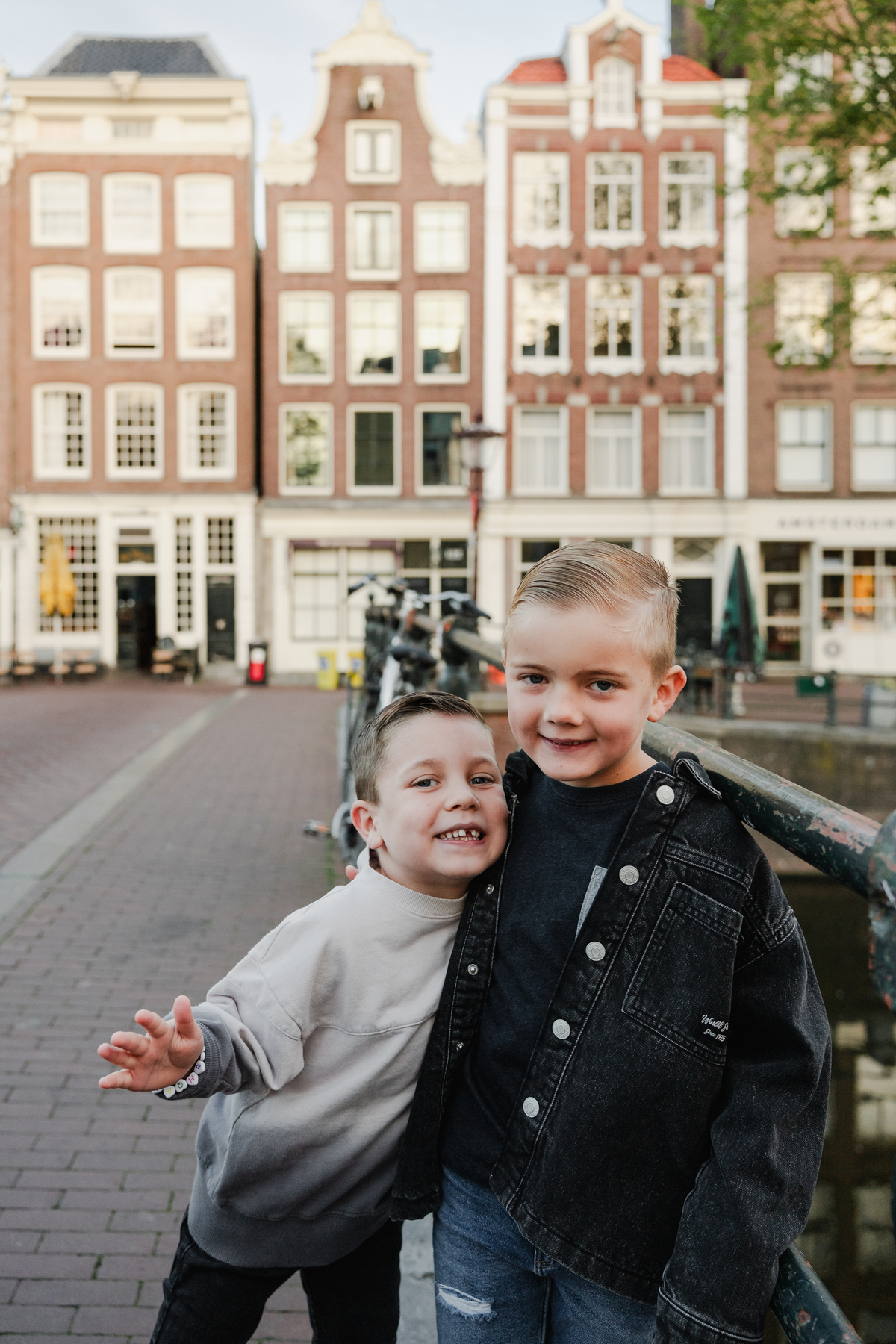 Two children smiling together during a family photo session in Amsterdam.