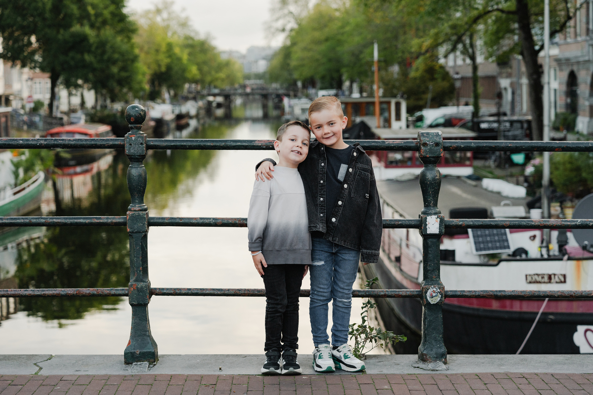 Family standing beside an Amsterdam canal during an early morning photo session.