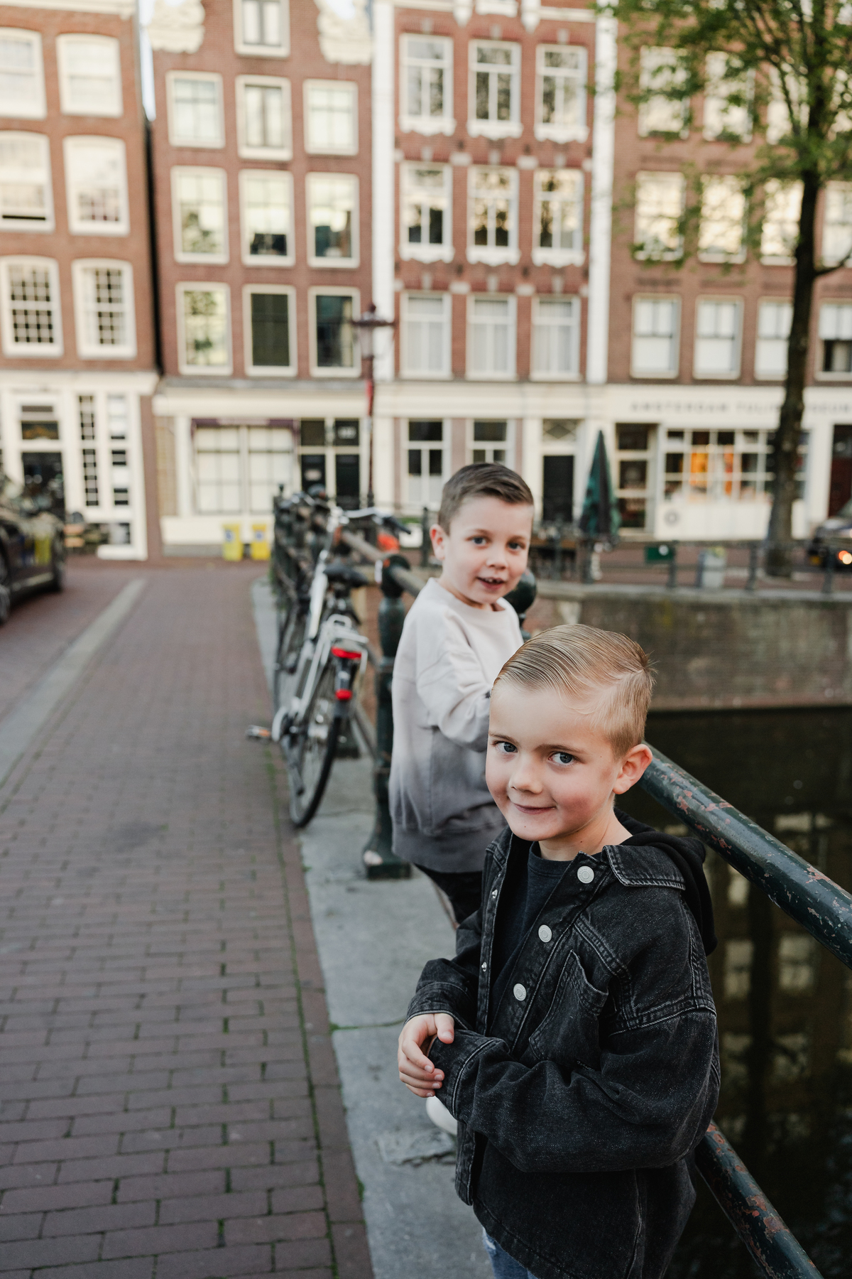 Two children standing together on a quiet Amsterdam street.