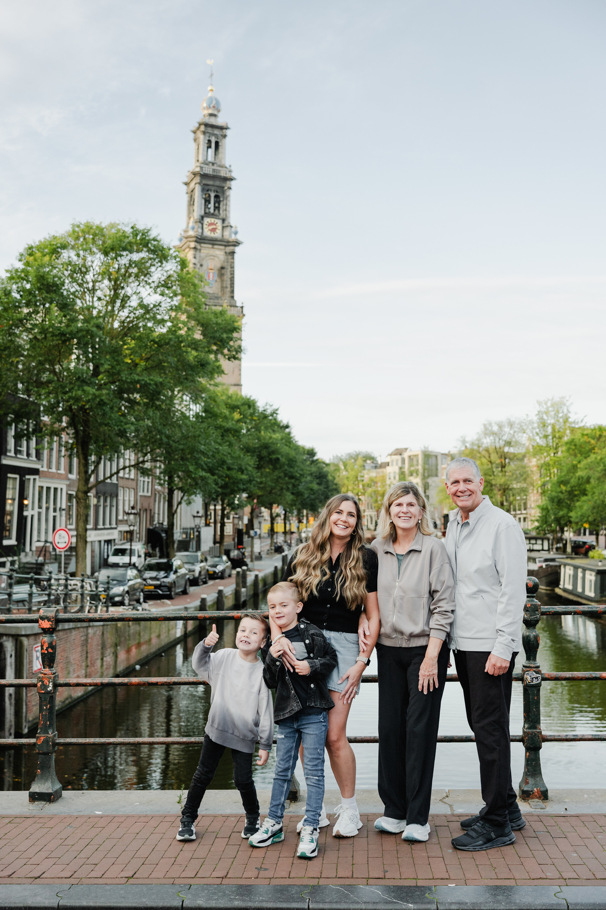 Multi-generational family standing together beside an Amsterdam canal.