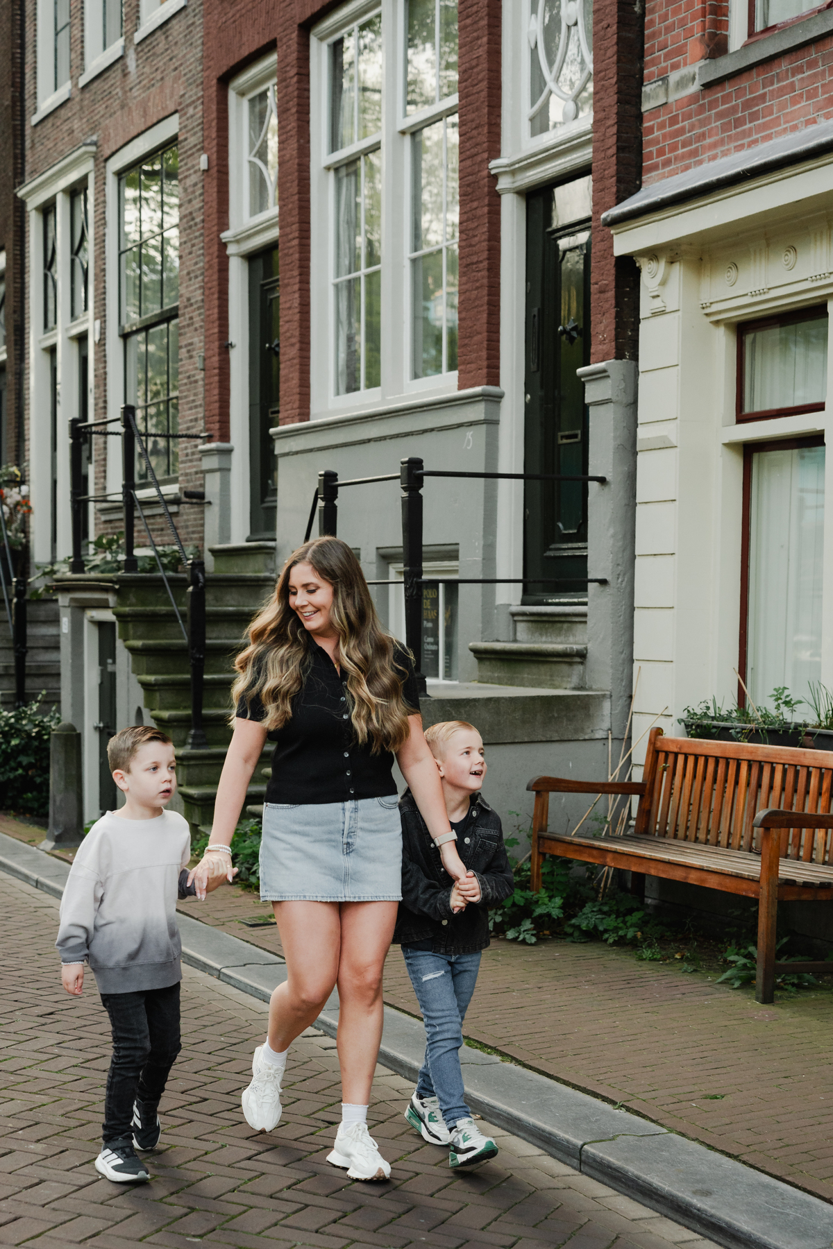 Parent and children walking along a quiet street in the Jordaan.