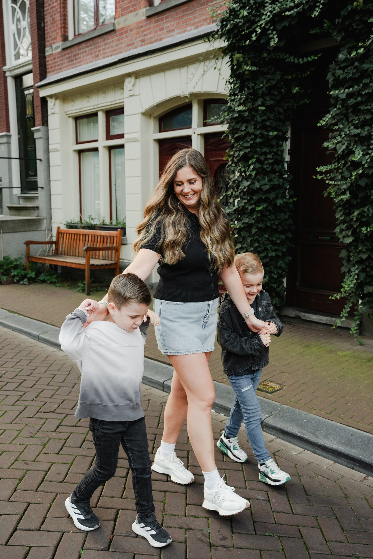 Parent holding hands with children during a family walk in Amsterdam.