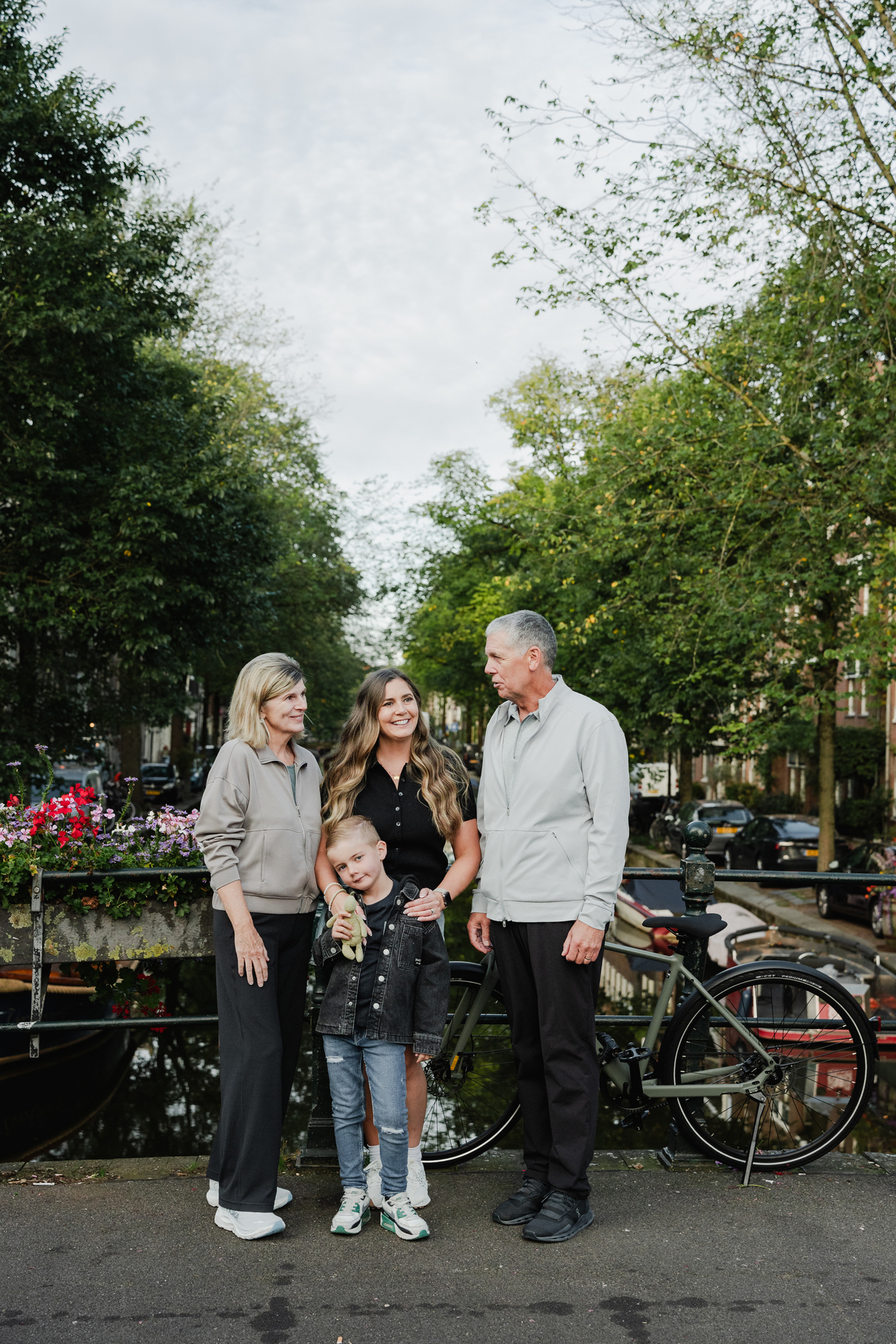Multi-generational family standing together beside an Amsterdam canal.