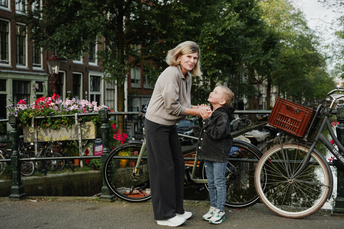 grandmother and grandchild in front of a canal of amsterdam next to bicycles during a family photo session