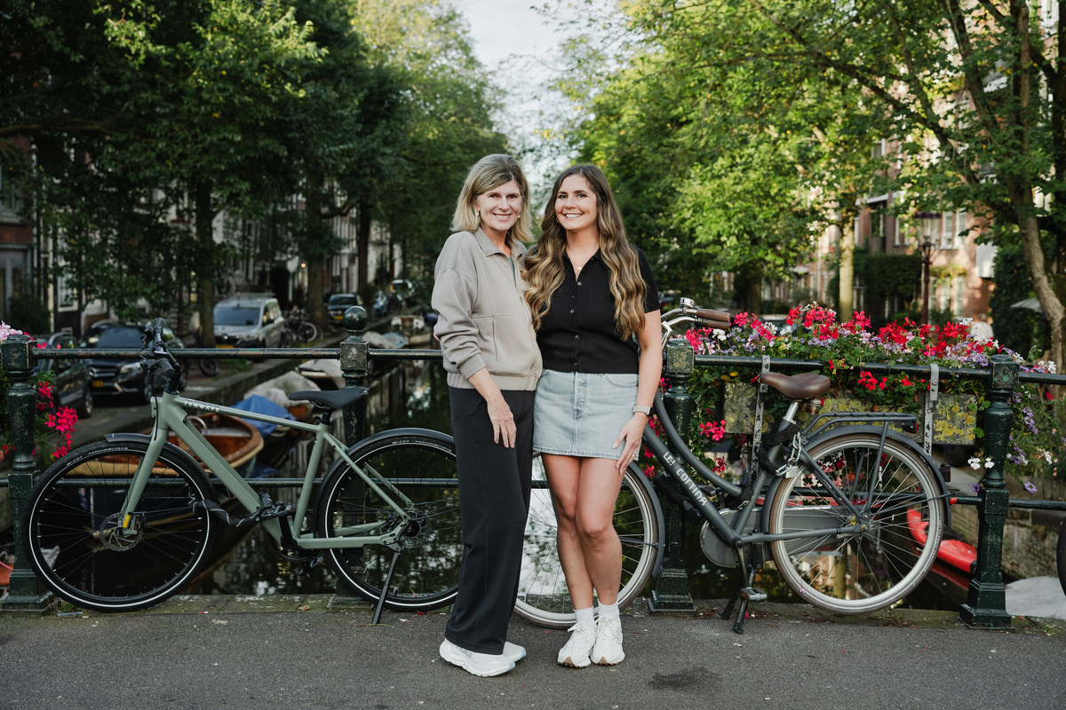 mother and daughter in front of a canal of amsterdam next to bicycles during a family photo session