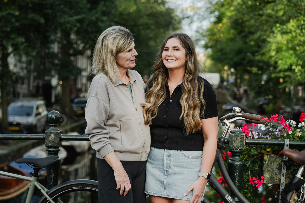 mother and daughter in front of a canal of amsterdam next to bicycles during a family photo session