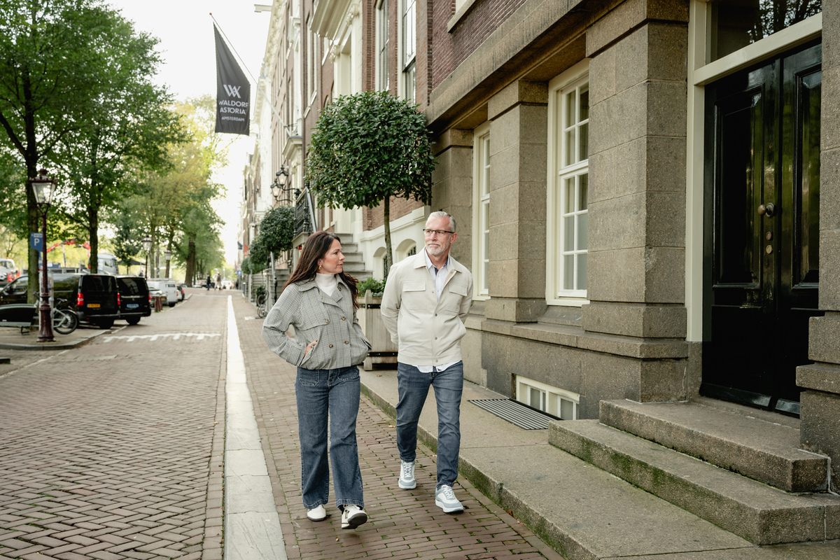 Couple walking together beside a quiet Amsterdam canal.