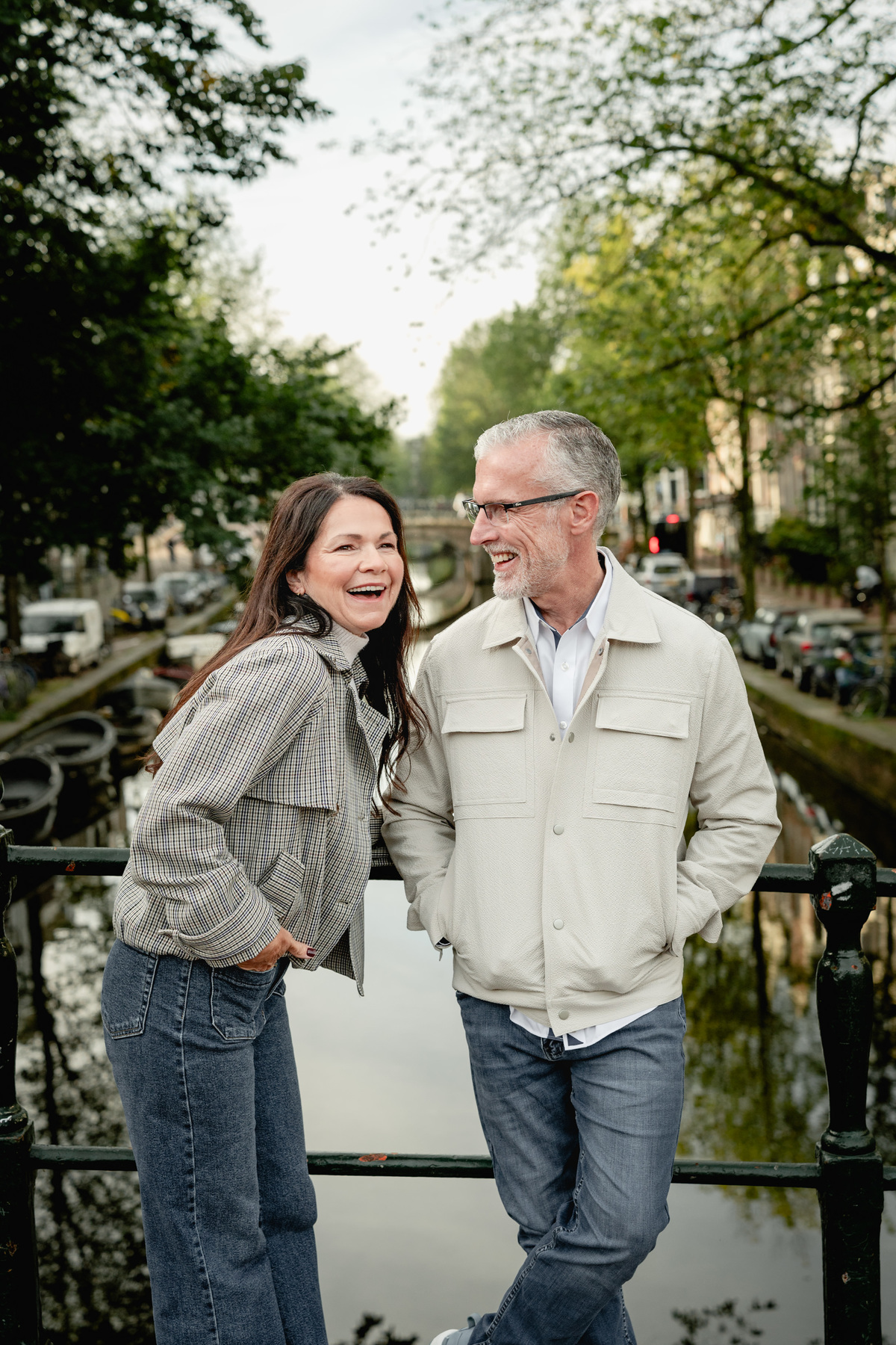 Close portrait of a couple smiling together beside an Amsterdam canal.