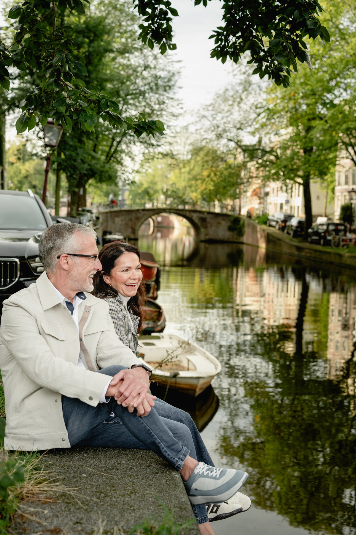 Close portrait of a couple sitting together and enjoying a quiet Amsterdam canal.