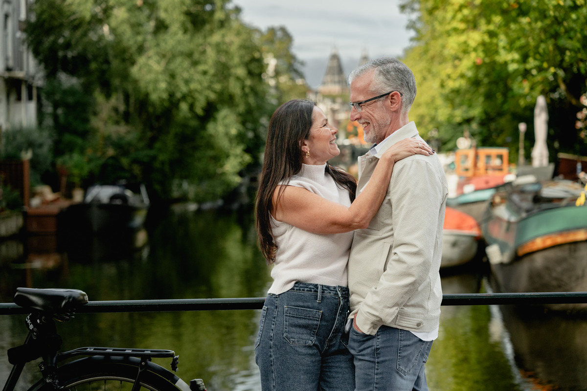 Couple embracing beside an Amsterdam canal during a natural couple photo session.