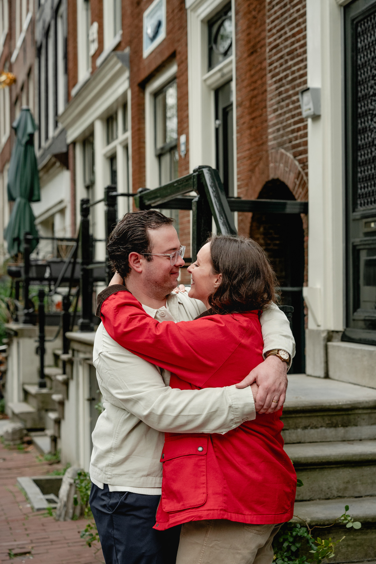 A couple embracing on a quiet Amsterdam street during their photo session.
