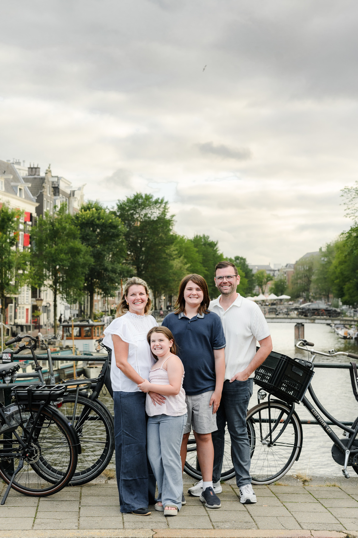 Family posing together on a quiet Amsterdam canal street.