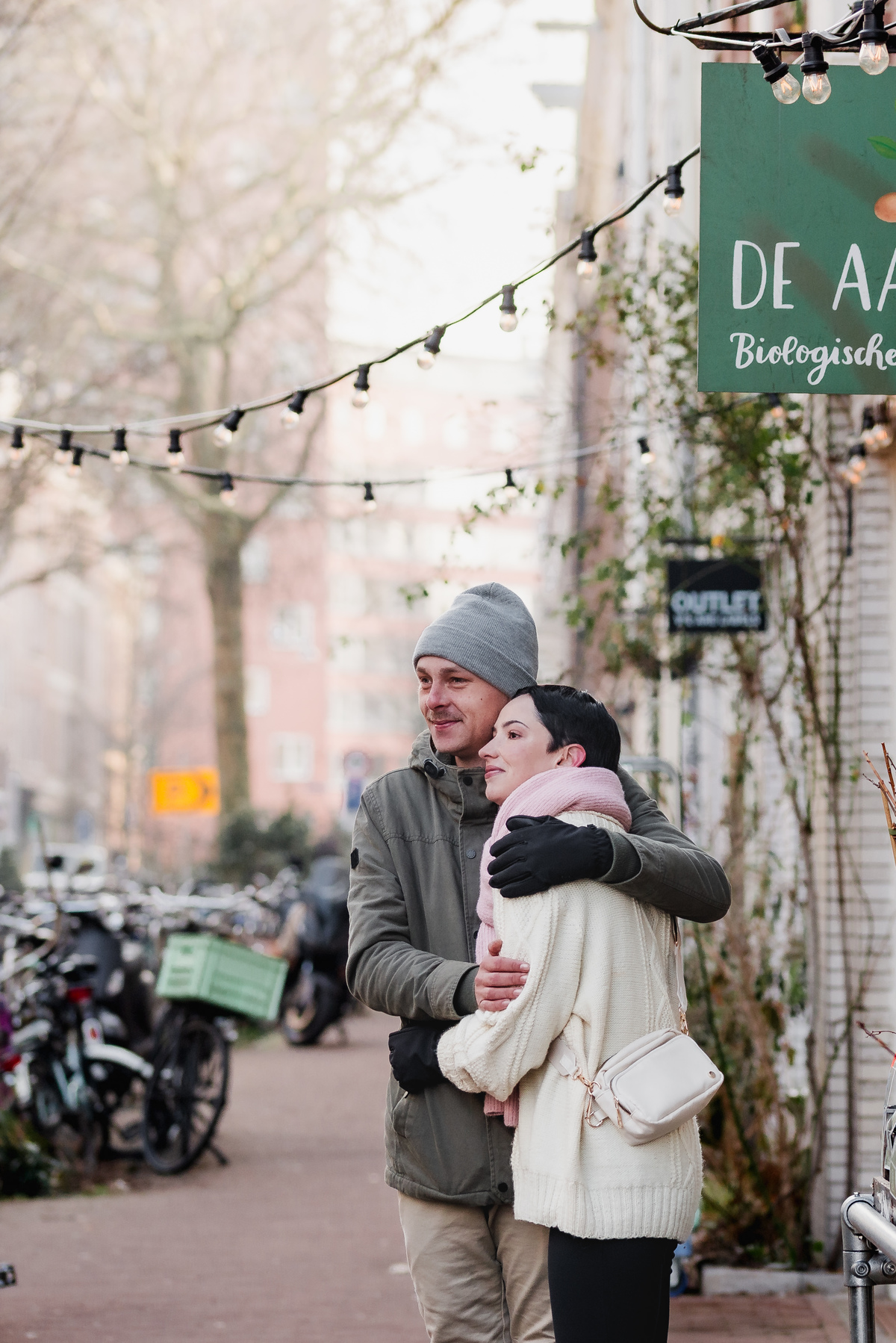 Couple embracing on a quiet Amsterdam street during their winter photo session.