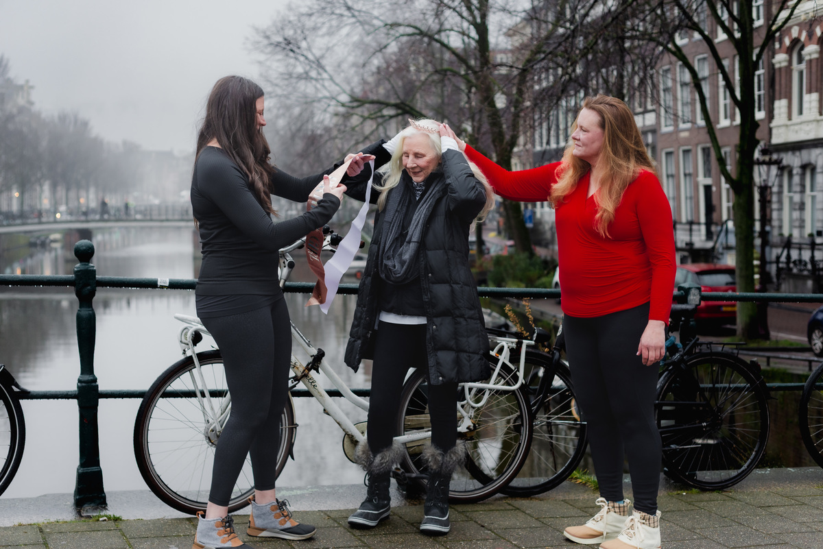 Family members celebrating together beside bicycles and a canal in Amsterdam.