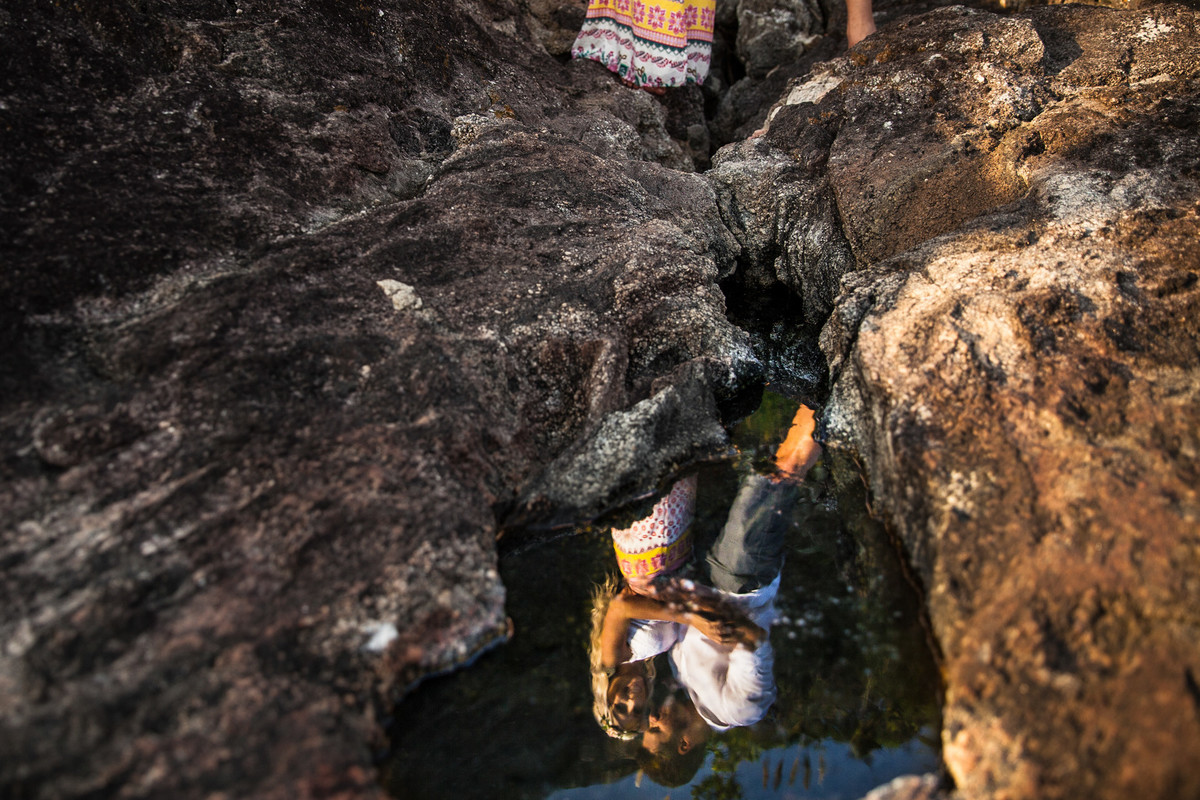 fotos de ensaio, pre wedding dos noivos em Guarujá, noivo abracando a noiva imagem espontanea, Praia das Conchas no Guaruja, São Paulo com reflexo na agua