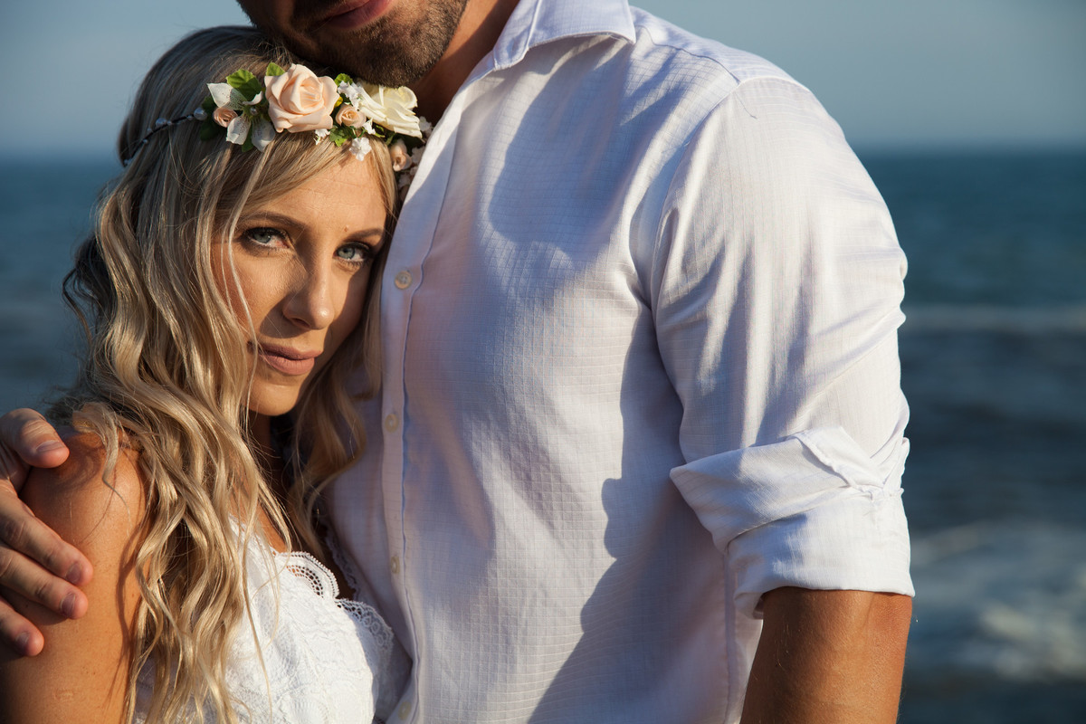 fotos de ensaio, pre wedding dos noivos em Guarujá, noivo abracando a noiva imagem espontanea, ela apoiada no peito o noivo, Praia das Conchas no Guaruja, São Paulo