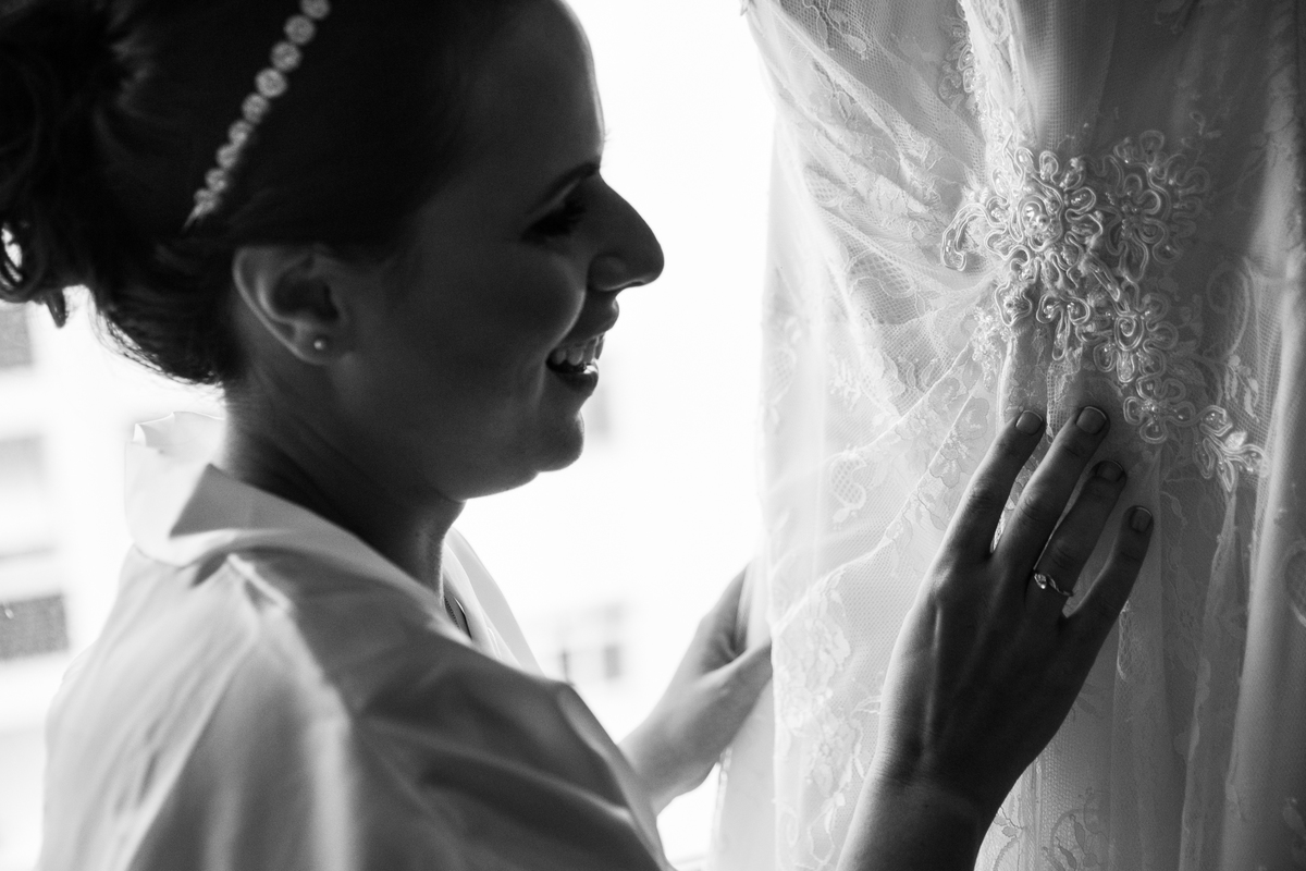 noiva admirando detalhes do vestido de casamento no making of
