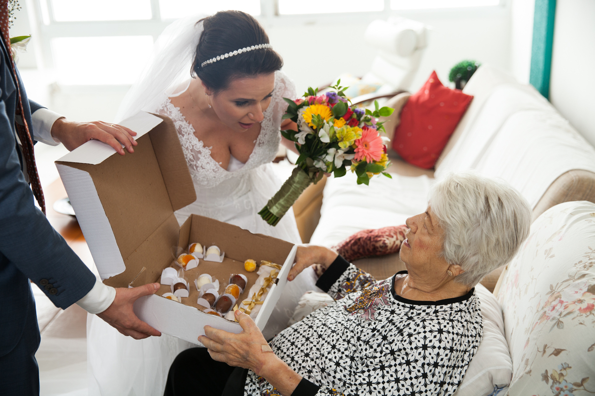 noiva dando os docinhos para sua avo que estava no casamento