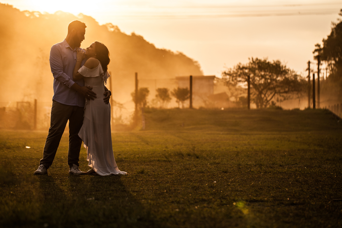 fotos de ensaio, pre wedding dos noivos em Paranapiacaba, noivo abracando a noiva, Paranapiacaba, São Paulo - Sp com leve poeria ao fundo