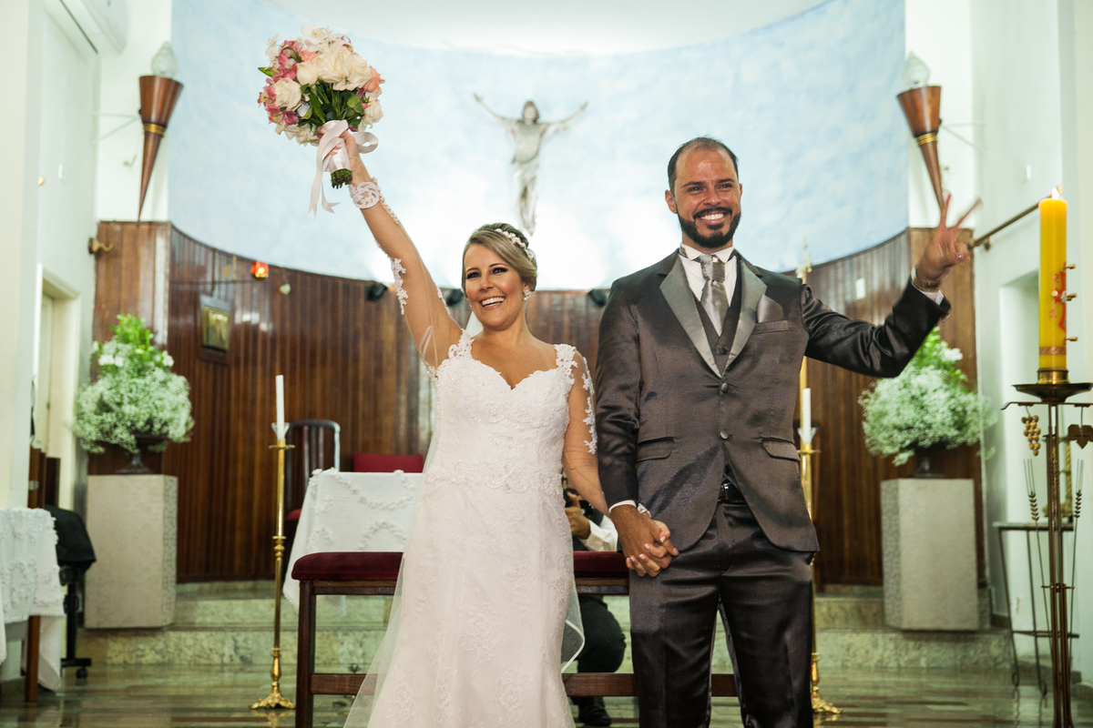 noivos comemoram o casamento na saida do altar