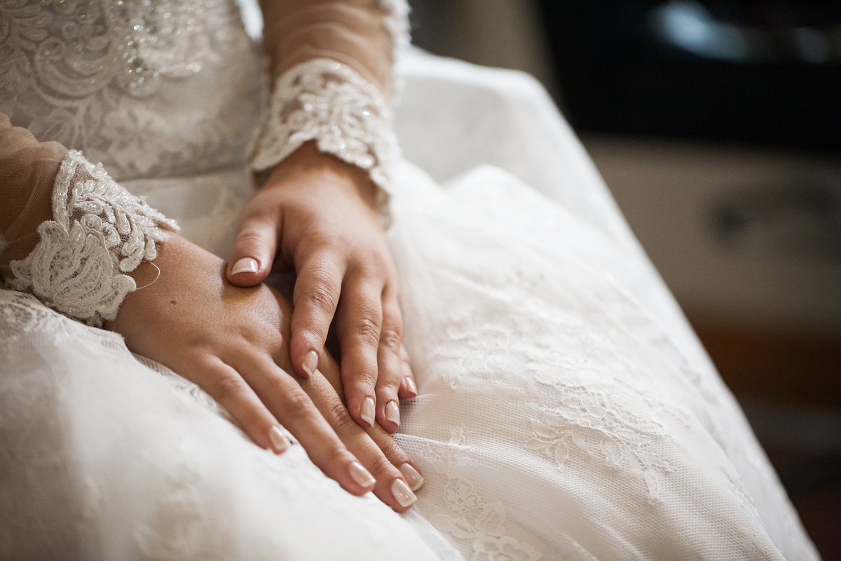 detalhes do vestido e maos da noiva sobre o vestido no dia da noiva