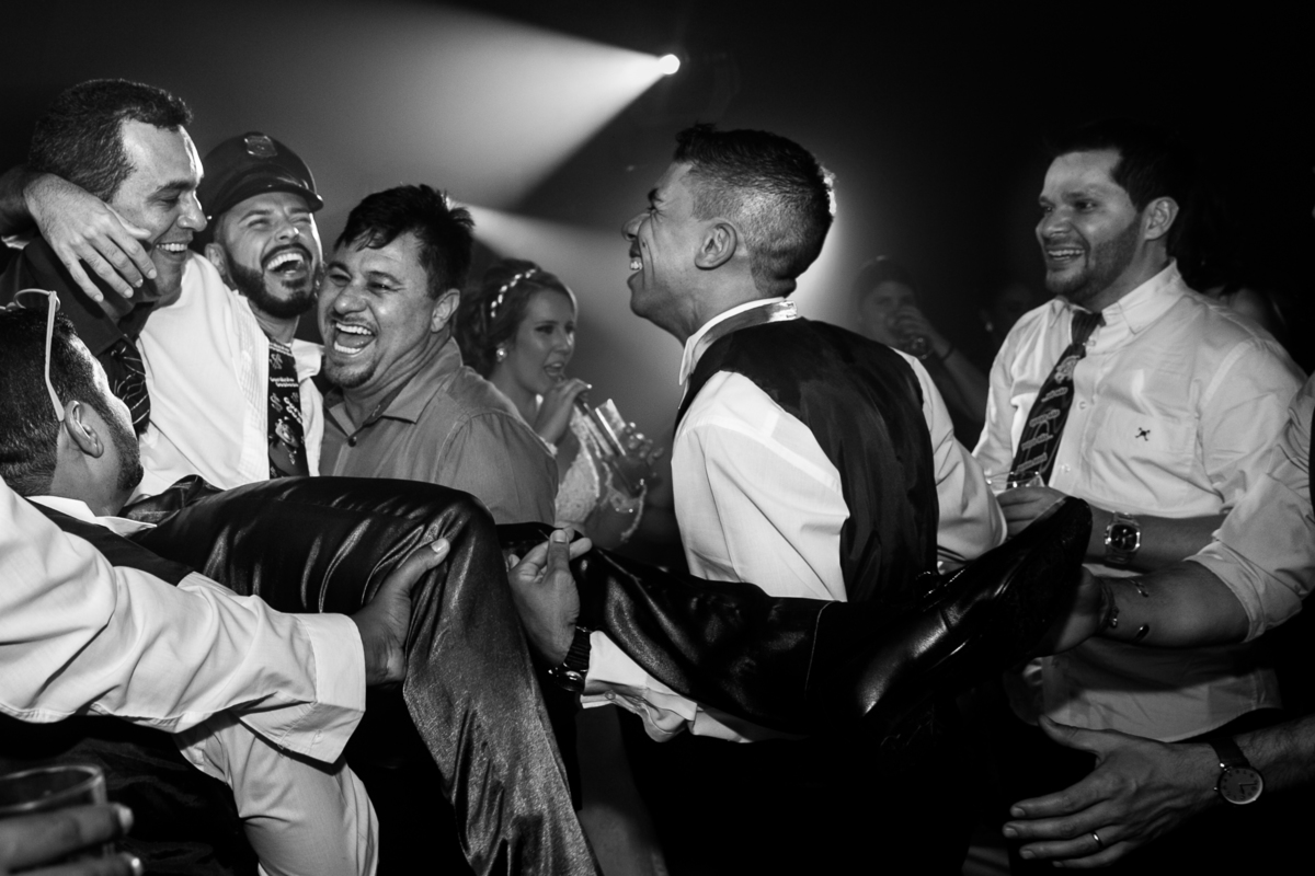 Noivo sendo carregado pelos amigos no dia do casamento, buffet Orion, Santos, Sao Paulo - SP