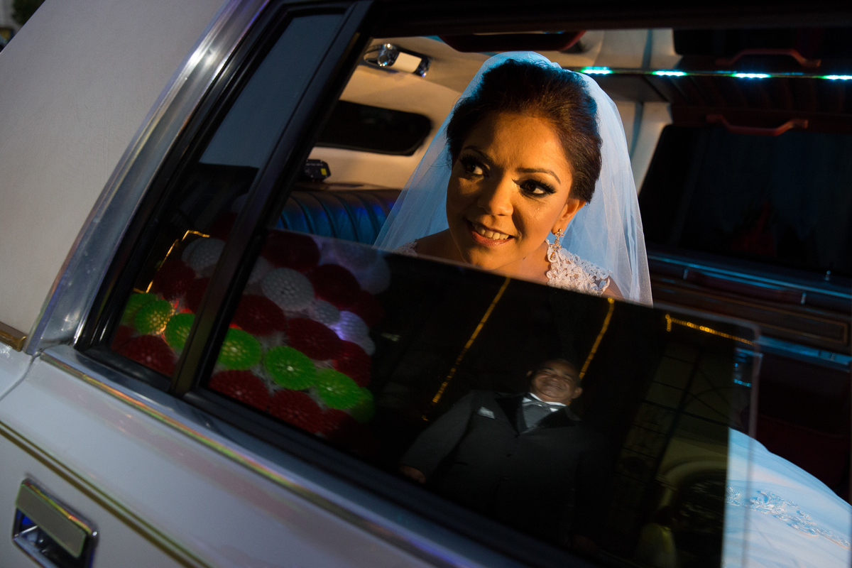 imagem da noiva no carro com reflexo no vidro, momentos antes da entrada 