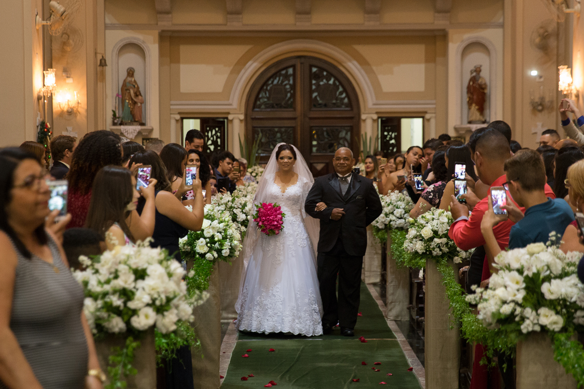 noiva com vestido lindo e buque rosa, entrando com o pai