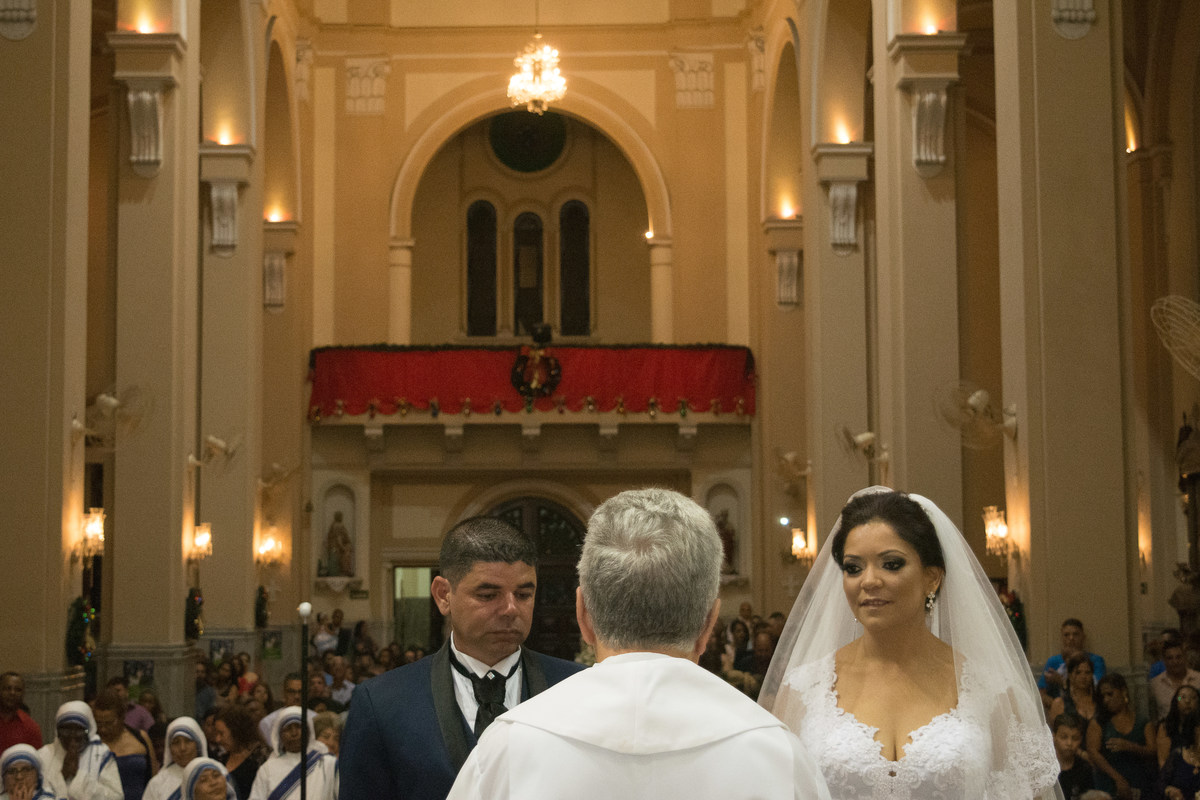 visao dos noivos com o padre de costas, com vista inteira da igreja