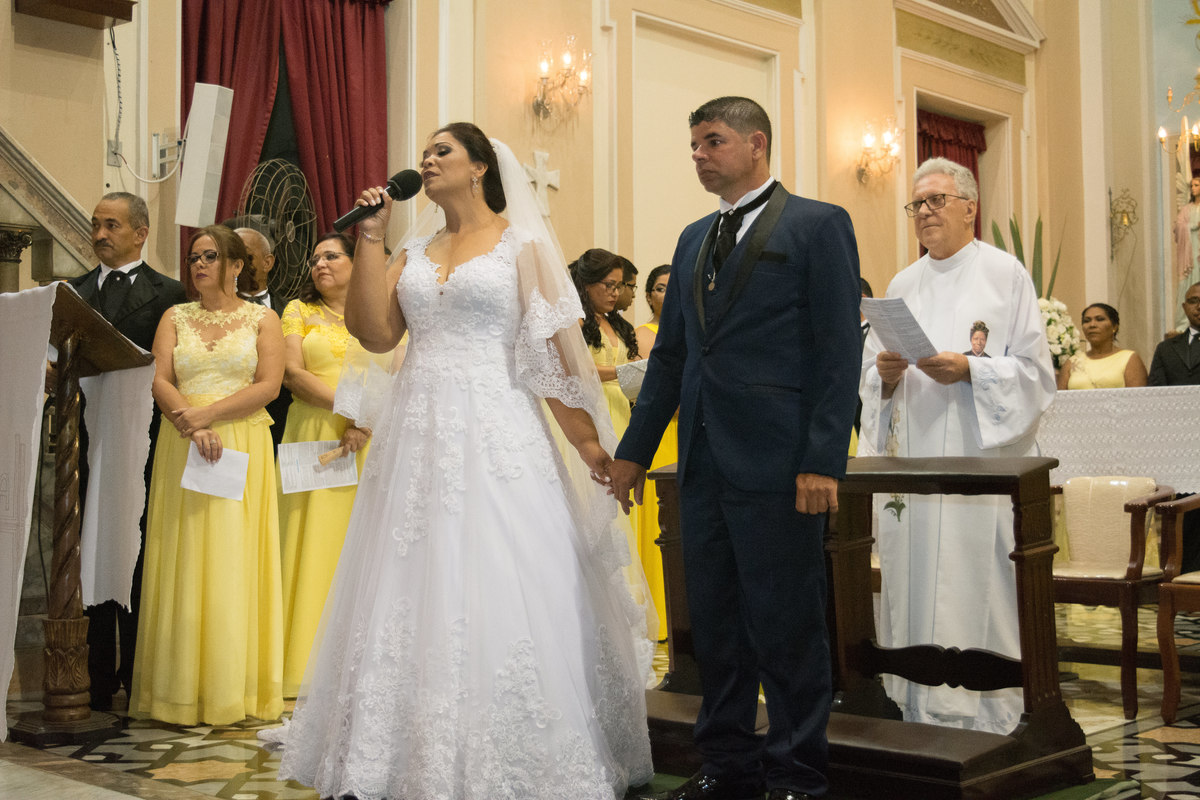 Noiva cantando no seu casamento e noivo ao seu lado