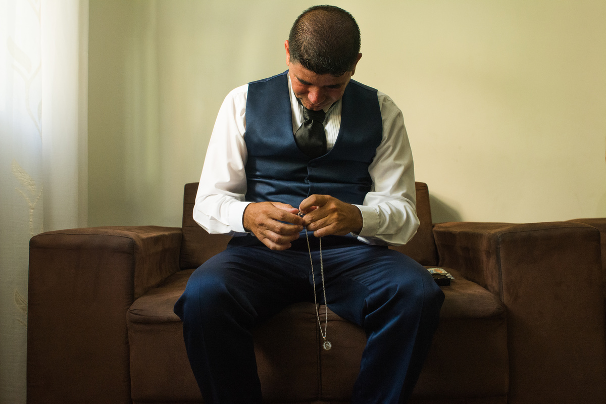 noivo eduardo vendo o presente que ganhou da noiva, uma corrente com imagem