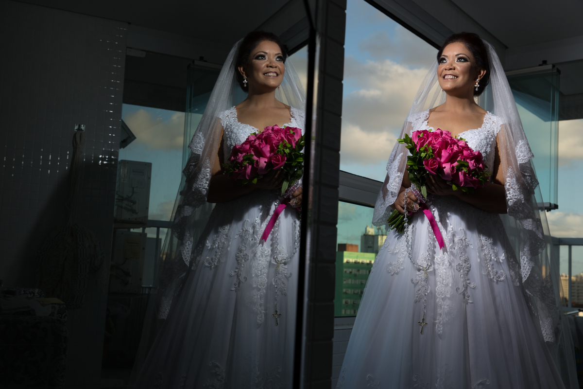 noiva pronta para casar, na sacada do predio com uma visao linda e reflexo na porta