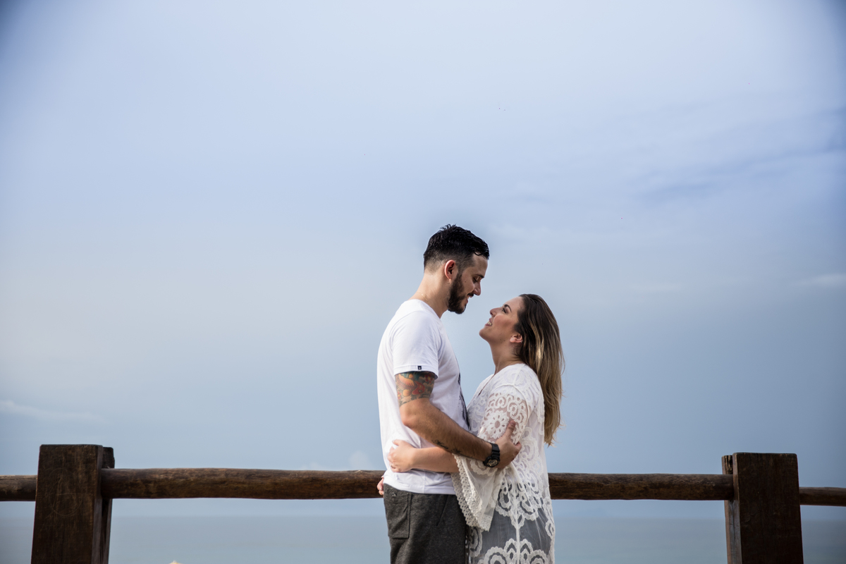 fotos de ensaio, pre wedding dos noivos em maresias, noivo abracando a noiva, Maresias, São Paulo - Sp com ceu azul lindo de fundo