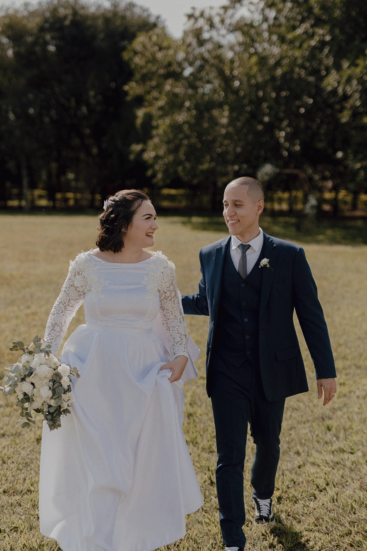 Casal caminhado no campo pós cerimonia de casamento 