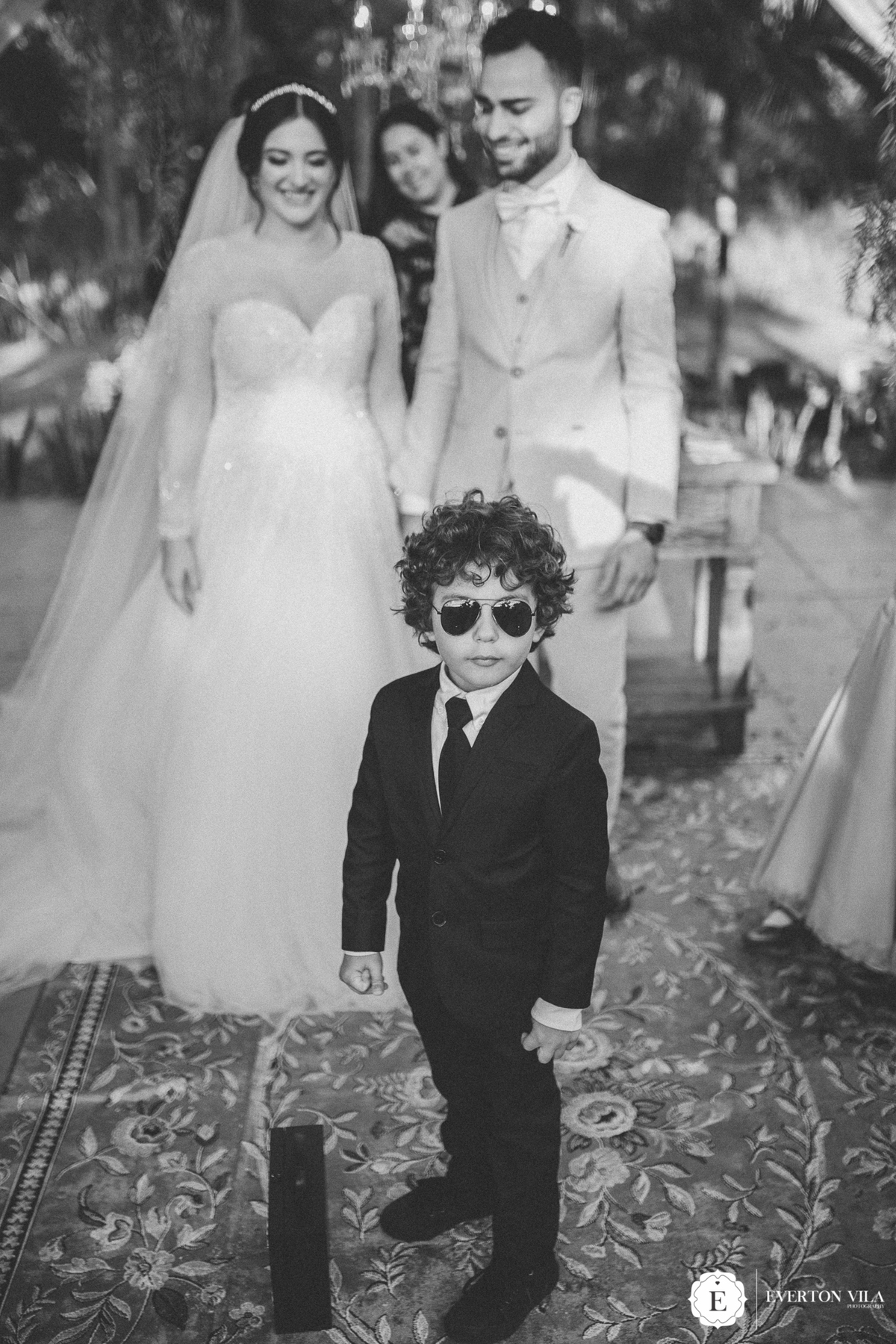 Pagem na entrada das alianças de terno perto e óculos de sol