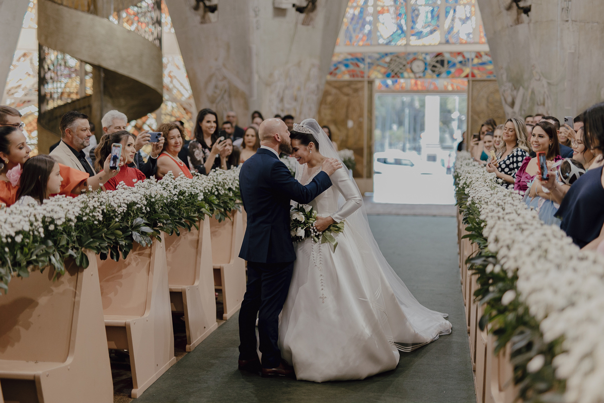 Noivo beijando a testa da noiva em casamento na igreja